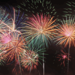 夜空中同時綻放的多個彩色放射狀煙火，包含紅、綠、黃、紫等鮮艷色調。